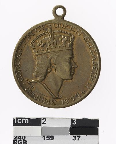 Round medal with profile of a crowned woman, text surrounding.
