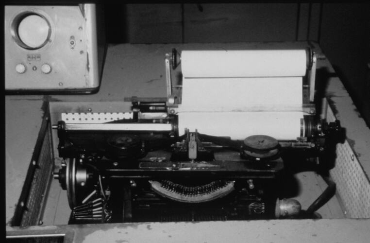 Typewriter like machine located on computer console.