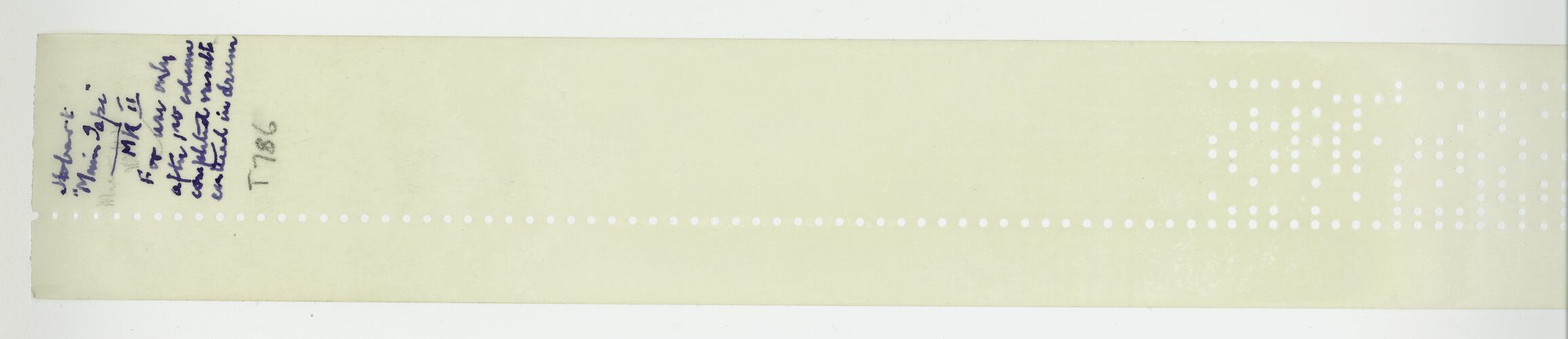 Length of paper tape with punched holes, text.