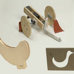 Wooden model of duck body - has no head or legs. Wooden model od cart with two wheels. Stencil of duck profile