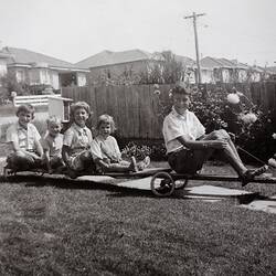 Boy on Billy Cart Towing Four Children on Trailer, Mount Waverley, 1961