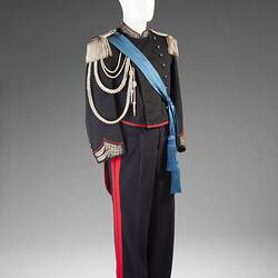 Military uniform with blue shash and feathered hat.