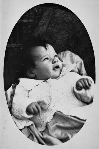 Portrait of baby in oval frame.