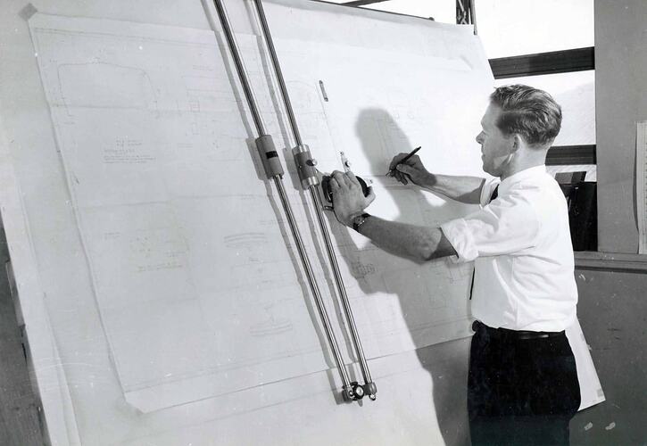 Man working on draughting table in office.
