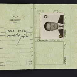 Open passport, white pages. Photo of man. Printed and written text.