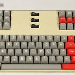 Computer keyboard, with grey and bright red keys.