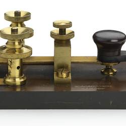 Ebonite base. Brass key with ebonite knob. Brass screw terminals. Profile.