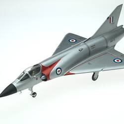 Plastic model aeroplane painted silver with red stripes and red, white and blue bulleyes on the wings.