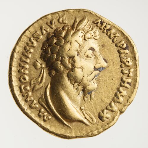 Round gold coin. Draped, wreathed bust of man facing right. Text around.