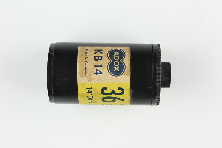 Cylindrical black plastic cartridge with printed paper label.