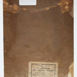 Brown cardboard back of photograph with adhered labels.