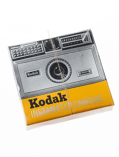 Square cardboard cigarette packet. Design on front represents a Kodak Instamatic Camera.