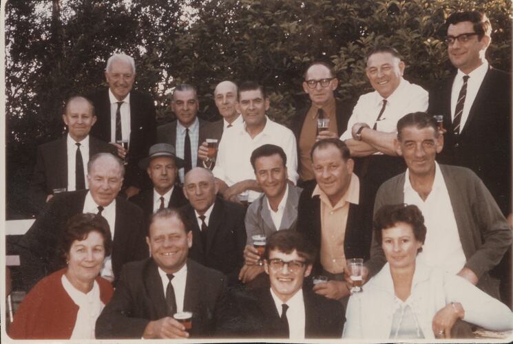 Mostly male group portrait outside, holding beer.