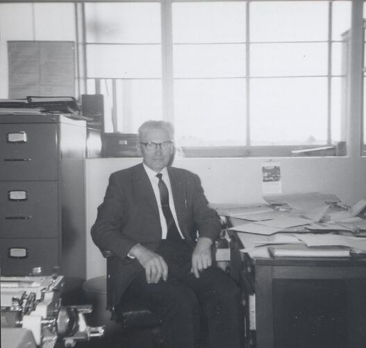Man seated in office chair.