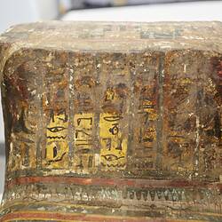 Egyptian coffin, lid end decorated with colourful patterns and pictures.