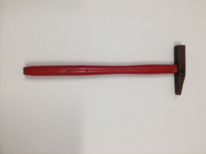 Metal hammer with red wooden handle.