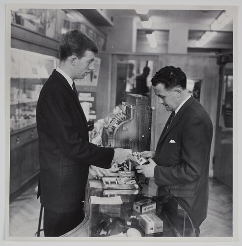 Two men at a sales counter.
