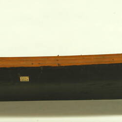 Wooden boat with black hull, facing right.