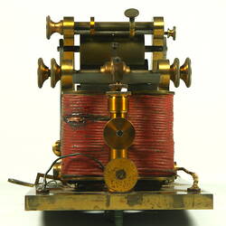 Brass apparatus with batteries on metal base.