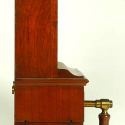 Wooden cabinet with wooden handle at base. Right profile shows two round brass discs near base, marked A and Z