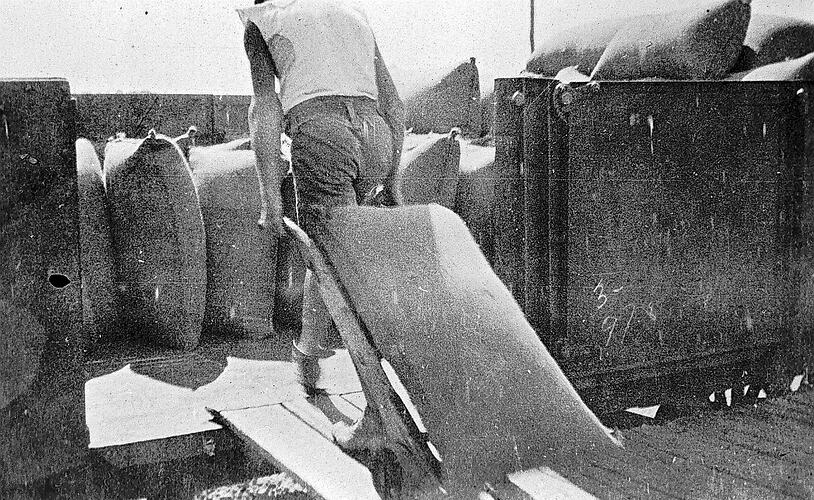 [Loading wheat into goods trucks, Nyarrin Station, circa 1920.]