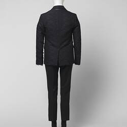 Back view of black suit made of textured black and grey wool blend fabric, Two pockets.