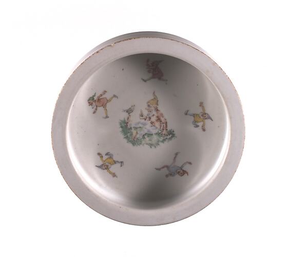 Round white ceramic bowl decorated with six faded elves.