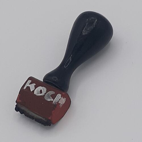 Rubber stamp with black wooden handle.