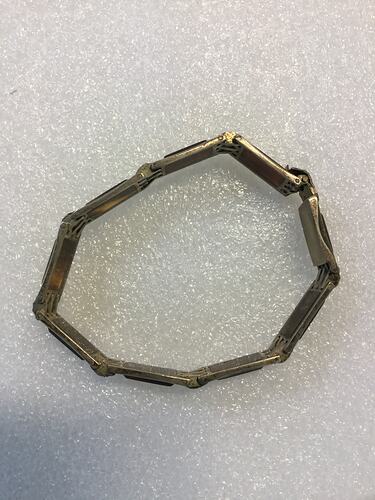 Bracelet made of hand-made silver links, each with tortoiseshell insets. Closed.