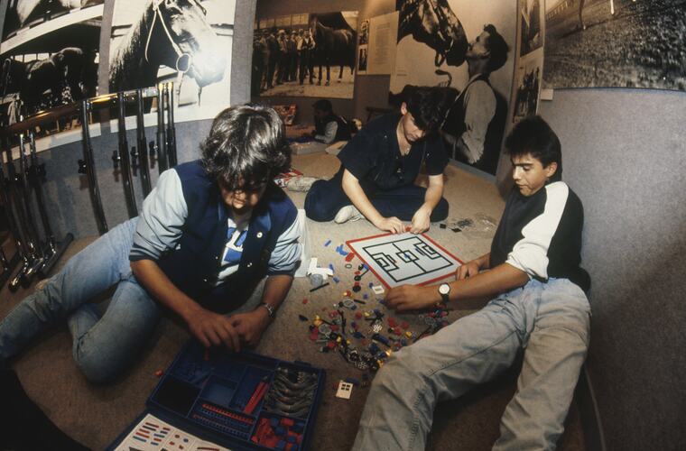 A group of students sitting on the floor playing with Lego.