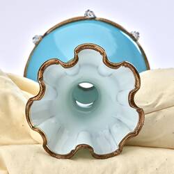 Top view of pale opaque blue glass vase with gilded frill edge. White interior.