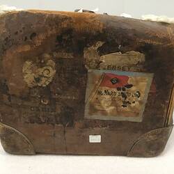 End of leather bag with remnant shipping labels.