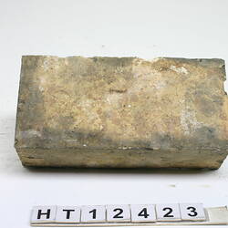Discoloured white, rectangular and worn machine pressed brick.