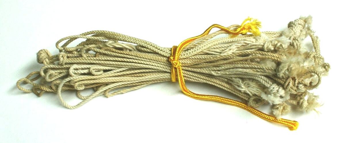 Bunch of off-white knotted cords.