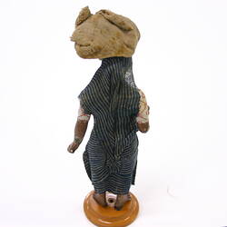 Reverse view of doll carrying grain.