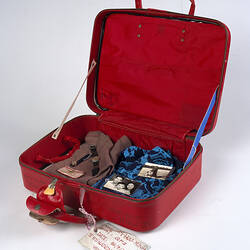 Detail of red vinyl suitcase with luggage tag.
