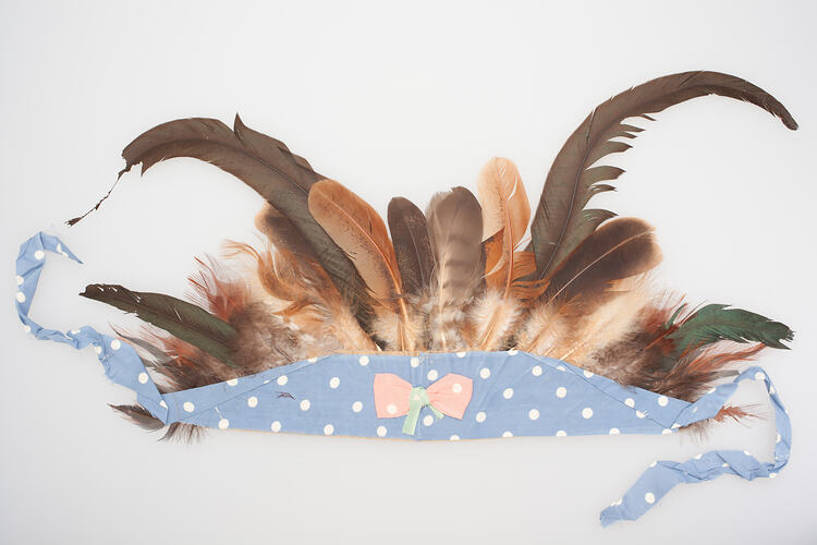 Headdress of feathers attached to blue and white spotted fabric