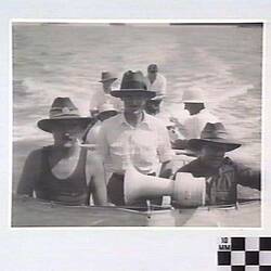 Men wearing hats aboard vessel, with loud speaker in front of then.