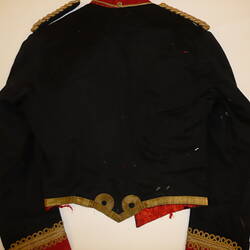 Black military uniform jacket with gold embroidery, back view.