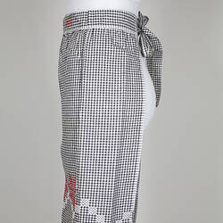 Front view of black and white gingham apron on mannequin.