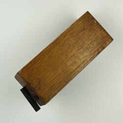 Rectangular brown block of wood, clip on back.