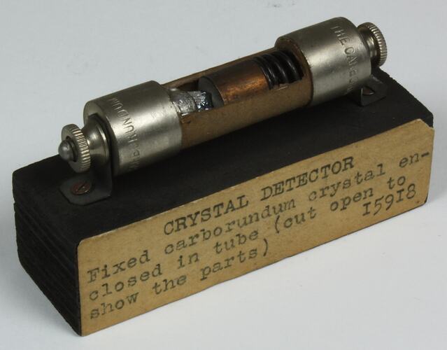 Crystal detector enclosed in a metal tube mounted on a wooden block.