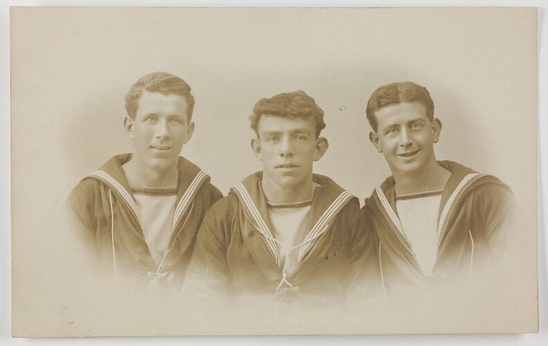 Studio portrait of three men in Navy uniform.