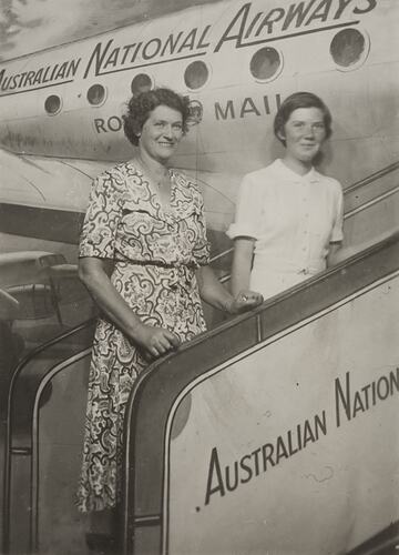Woman and girl pose in front of mock plane.