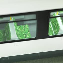 Tram model of articulated, low-floor tram. Detail of green seats viewed through windows.