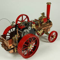 Model steam traction engine in metal, painted black and red.