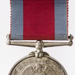 Silver medal with Victory seated on a pedestal with her wings spread. Text below. Medal suspended from ribbon.