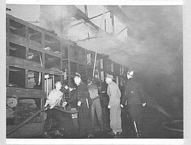 Firemen and workers during factory fire.
