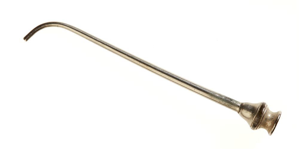 Long narrow stainless steel tube with curved tip and reel-shaped end with a narrow knurled ring.