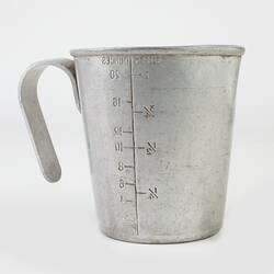 Tin measuring jug with handle. Stamped on inside with Pint/Ounce measurements.